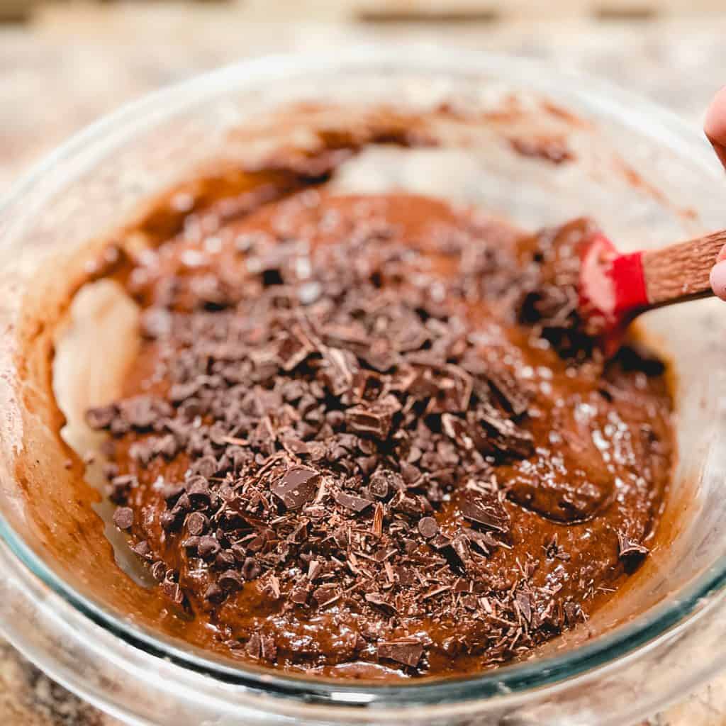 Folding chocolate into muffin batter.