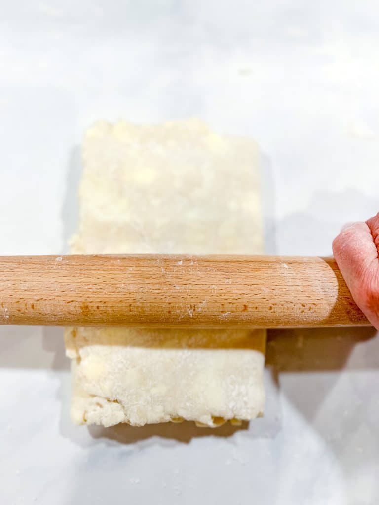 Rolling out puff pastry dough.